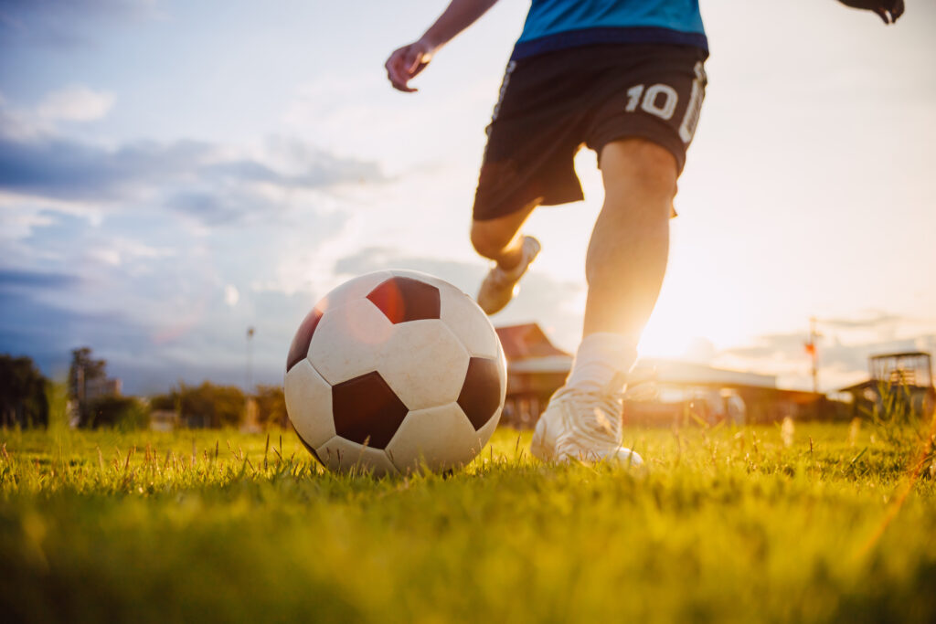 Action shot of young child kicking soccer ball