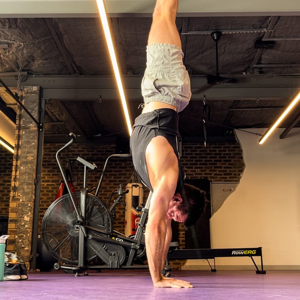 Image of Keen Podiatry owner, Matt, doing a handstand at gym.