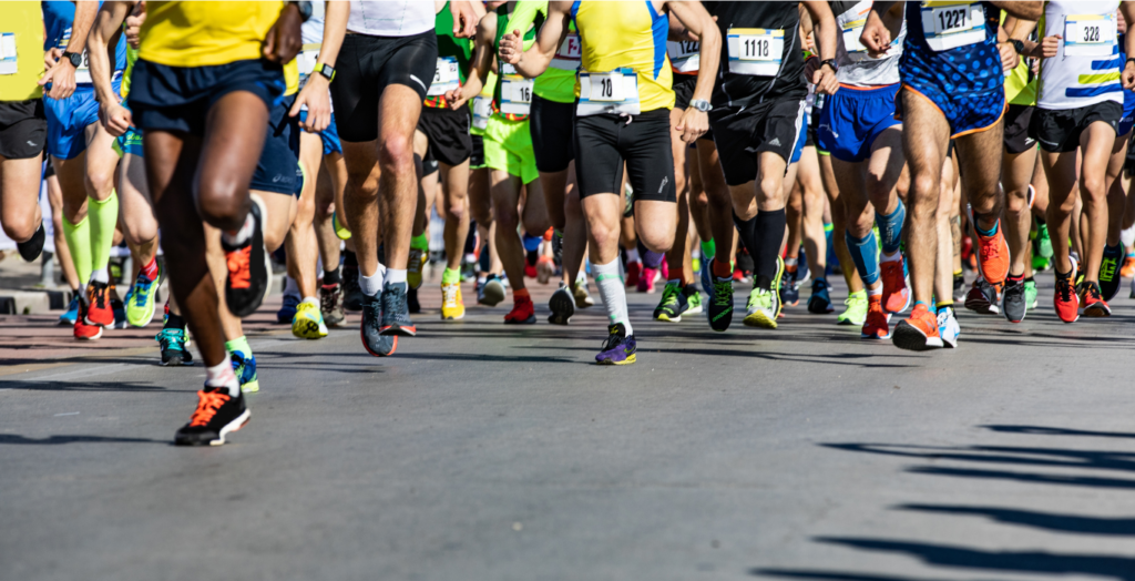 Image of multiple runners during a race, with a focus on legs.